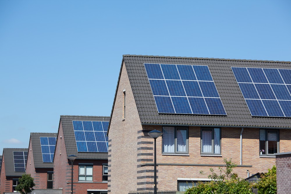 Modern houses with solar panels on the roof for alternative energy.