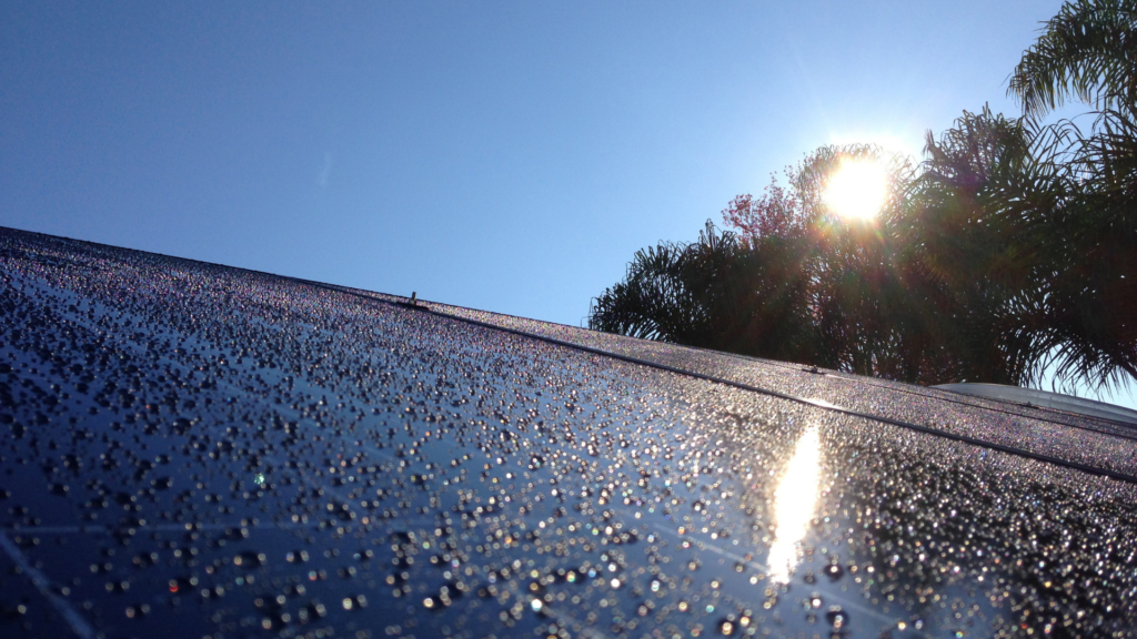 rain on residential solar panel during a sunny day