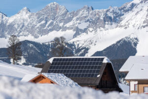 Solar panels can be seen on the roof of a home during winter. Snow is all around and it appears to be extremely cold.