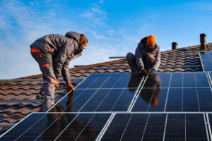 Two Men Installing Solar Panels on a Roof